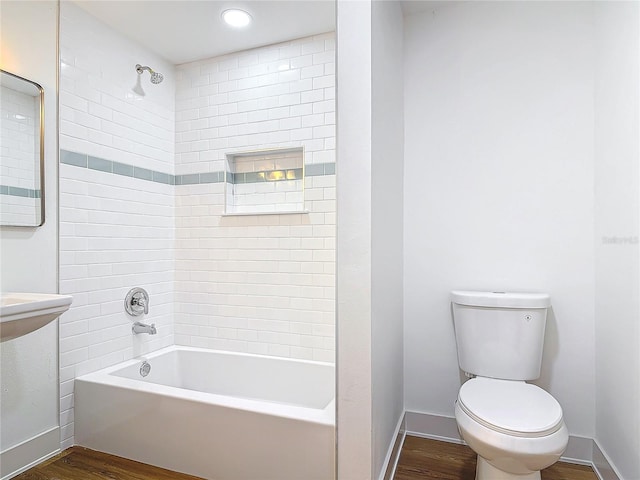 bathroom featuring shower / bath combination, wood finished floors, toilet, and baseboards