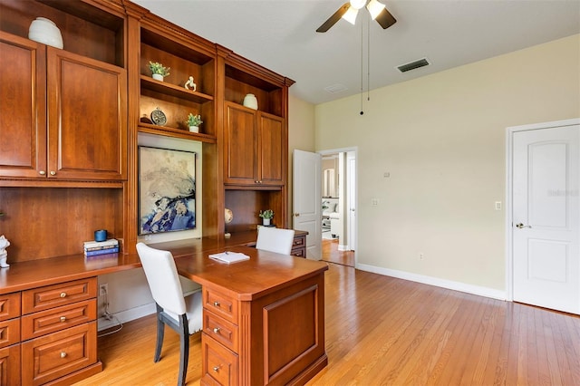 home office with a ceiling fan, visible vents, light wood-style flooring, and baseboards