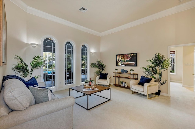 living area with ornamental molding, plenty of natural light, visible vents, and baseboards