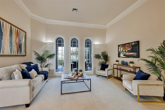 living area featuring visible vents, ornamental molding, and light colored carpet