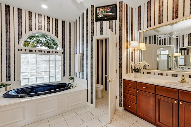 full bathroom with toilet, wallpapered walls, a healthy amount of sunlight, and a garden tub