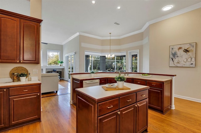 kitchen featuring white dishwasher, light wood-style flooring, visible vents, light countertops, and a center island with sink