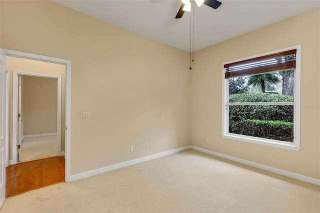 carpeted empty room with a ceiling fan and baseboards