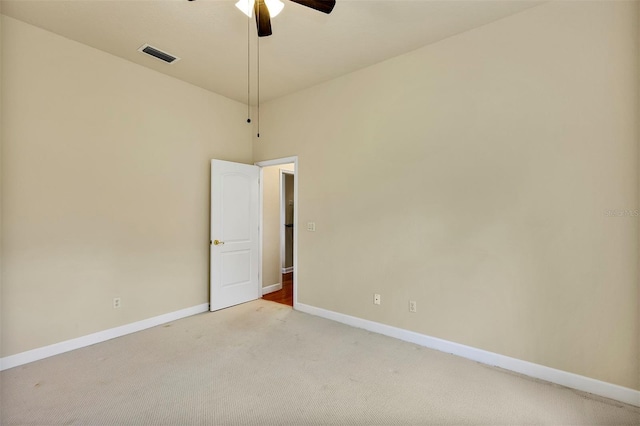 spare room with a ceiling fan, visible vents, light carpet, and baseboards