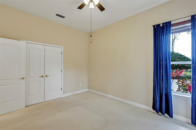 unfurnished bedroom with multiple windows, carpet, and visible vents