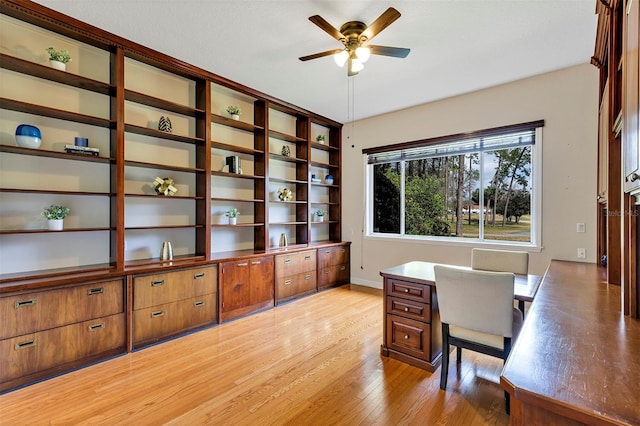 home office featuring baseboards, light wood-style flooring, and a ceiling fan