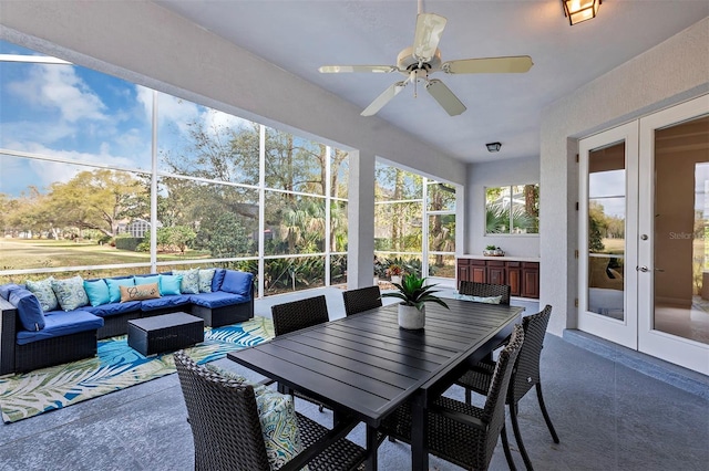 sunroom / solarium featuring a ceiling fan and french doors