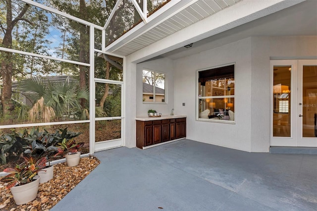 sunroom / solarium featuring a sink and french doors