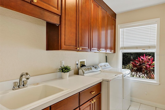 laundry room featuring washer and clothes dryer, light tile patterned floors, cabinet space, a sink, and baseboards