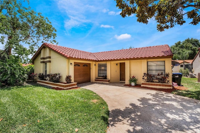 mediterranean / spanish-style home featuring a front yard, concrete driveway, an attached garage, and stucco siding