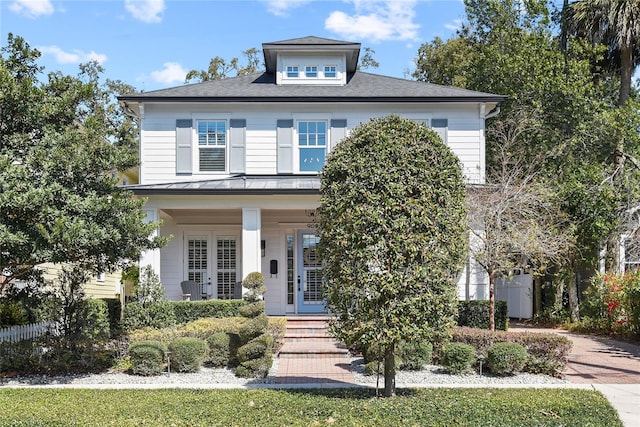 traditional style home with covered porch, metal roof, a standing seam roof, and french doors