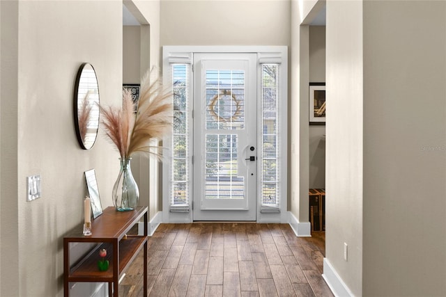 doorway to outside with baseboards and wood finished floors