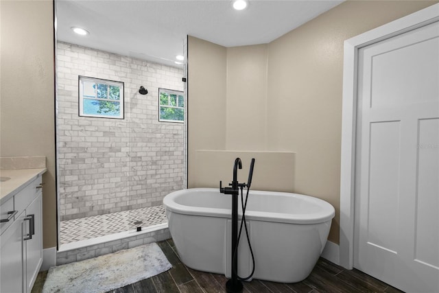 bathroom featuring wood tiled floor, a soaking tub, and tiled shower