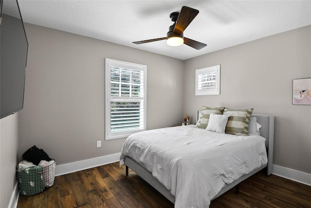 bedroom with ceiling fan, a textured ceiling, baseboards, and wood finished floors