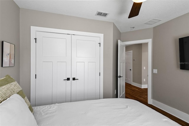 bedroom featuring a closet, wood finished floors, visible vents, and baseboards