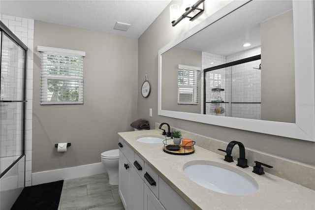 bathroom with a wealth of natural light, tiled shower, and a sink