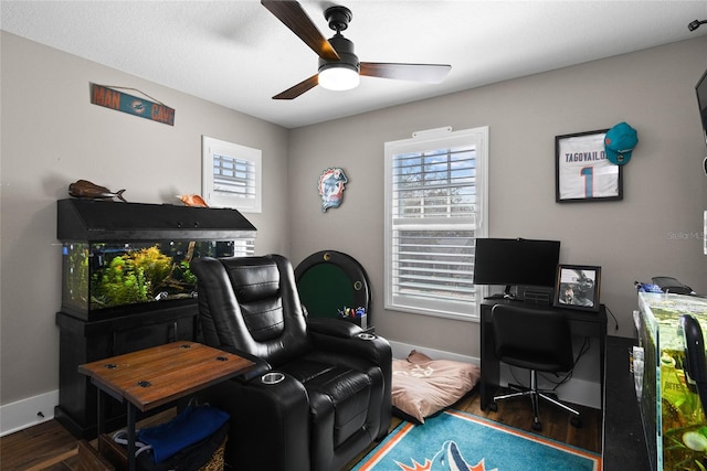 home office with wood finished floors, a ceiling fan, and baseboards