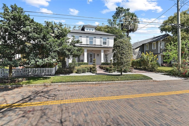 american foursquare style home with a standing seam roof, fence, and metal roof