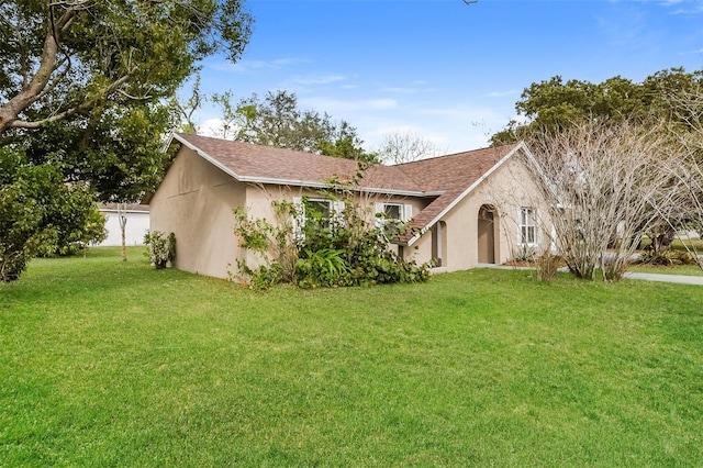 view of front of home featuring a front yard and stucco siding