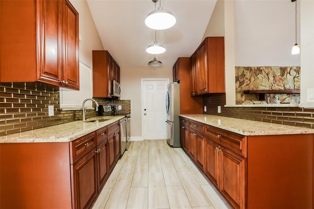 kitchen featuring light stone counters, decorative light fixtures, a sink, stainless steel appliances, and backsplash