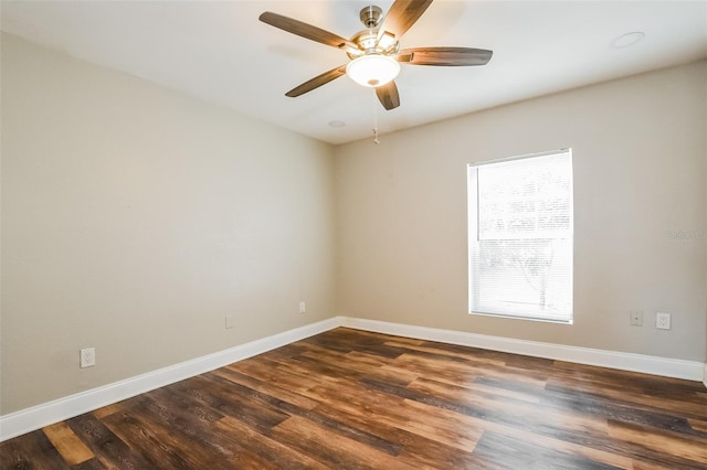 empty room featuring dark wood-style floors, baseboards, and a ceiling fan