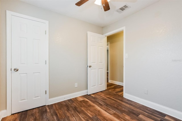 unfurnished bedroom featuring dark wood-style flooring, visible vents, ceiling fan, and baseboards