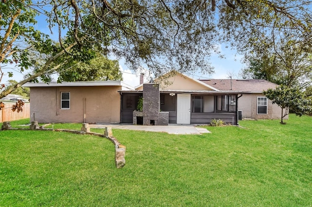 rear view of house featuring a yard, a chimney, stucco siding, a patio area, and fence