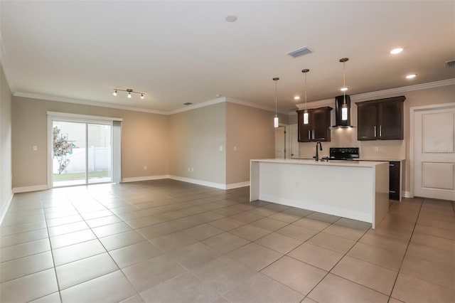 kitchen featuring wall chimney range hood, light countertops, crown molding, and light tile patterned flooring