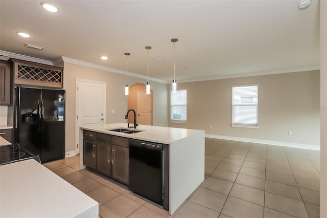 kitchen featuring a center island with sink, light countertops, black appliances, pendant lighting, and a sink