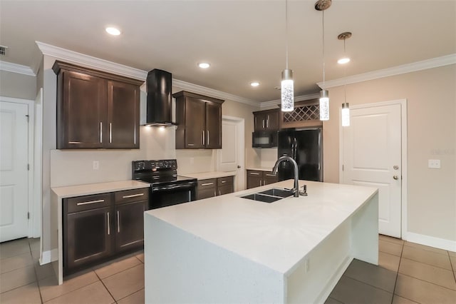 kitchen featuring a kitchen island with sink, a sink, wall chimney exhaust hood, black appliances, and pendant lighting