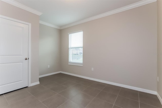 empty room featuring baseboards, ornamental molding, and tile patterned flooring