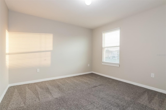 carpeted empty room with baseboards