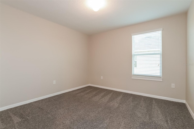 carpeted empty room with baseboards