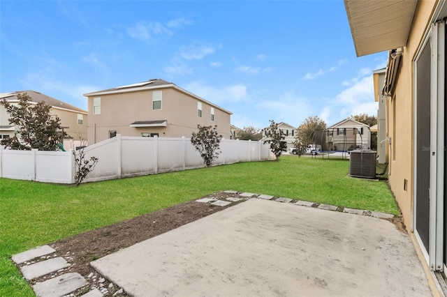 view of yard featuring a fenced backyard, a residential view, a trampoline, central air condition unit, and a patio area