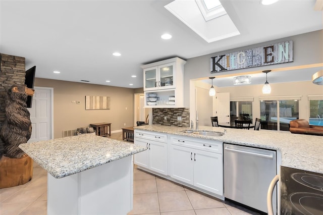 kitchen featuring backsplash, a skylight, stainless steel dishwasher, electric range, and a sink