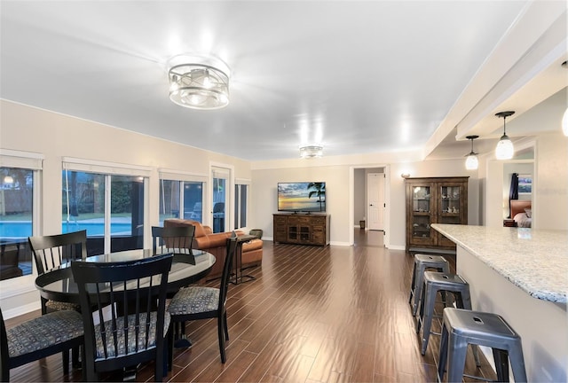 dining area with baseboards and dark wood-type flooring