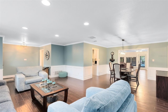 living area featuring crown molding, a notable chandelier, wood finished floors, and recessed lighting