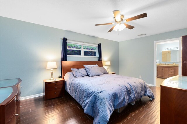 bedroom featuring wood finish floors, visible vents, ensuite bathroom, a sink, and baseboards