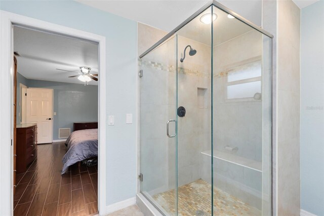 ensuite bathroom with a ceiling fan, visible vents, wood tiled floor, a stall shower, and ensuite bathroom