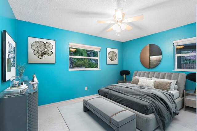 bedroom featuring baseboards, a textured ceiling, ceiling fan, and carpet