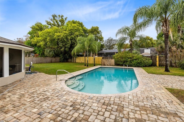 view of pool featuring a lawn, a patio, and a fenced backyard