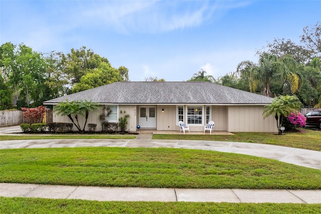 single story home featuring french doors, driveway, and a front lawn