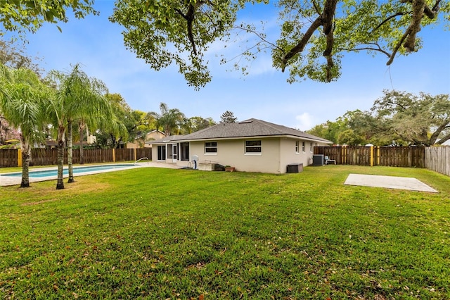 back of house featuring a fenced in pool, a patio, a lawn, and a fenced backyard