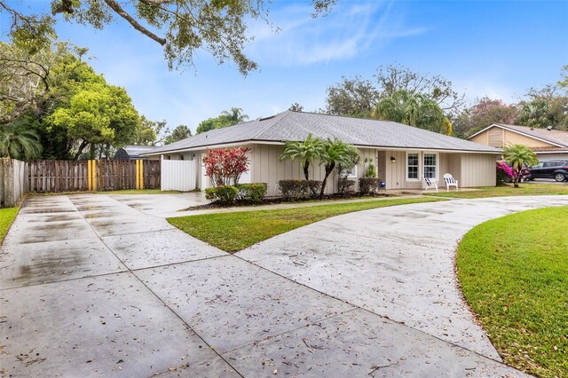 single story home featuring driveway, a front lawn, and fence