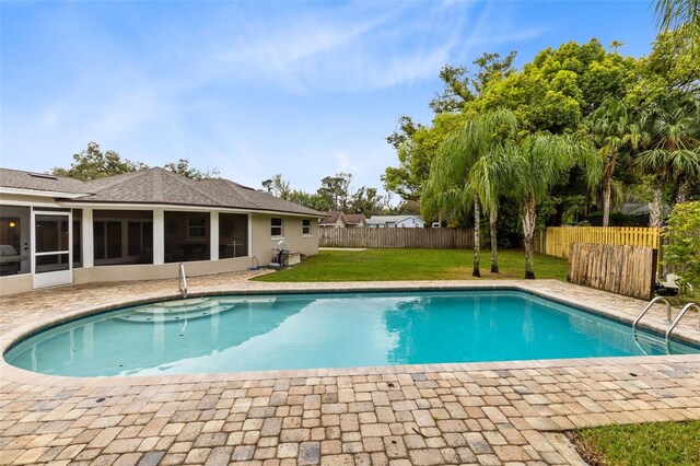 view of pool with a patio, a fenced in pool, a fenced backyard, a sunroom, and a lawn