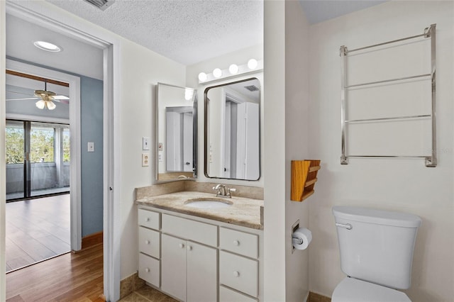 2297 Burnway Rd Unit 2297, Haines City, FL 33844 - bathroom featuring toilet, ceiling fan, wood finished floors, a textured ceiling, and vanity