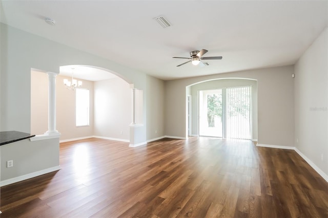 spare room with a ceiling fan, dark wood-style flooring, visible vents, and decorative columns