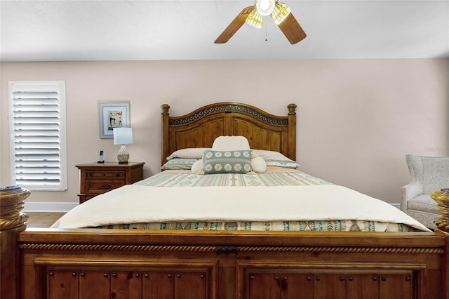 bedroom with ceiling fan, wood finished floors, and baseboards