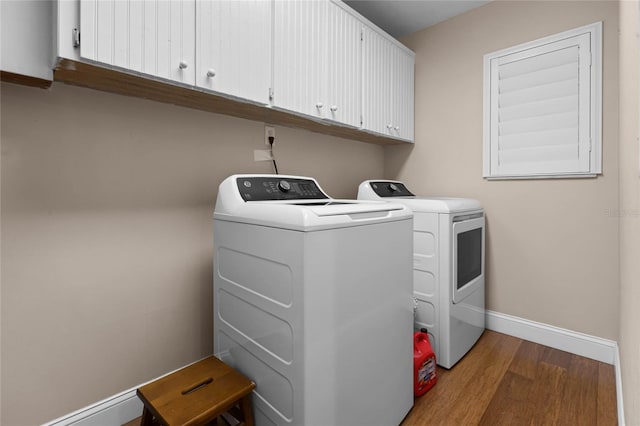 laundry room with wood finished floors, cabinet space, baseboards, and separate washer and dryer