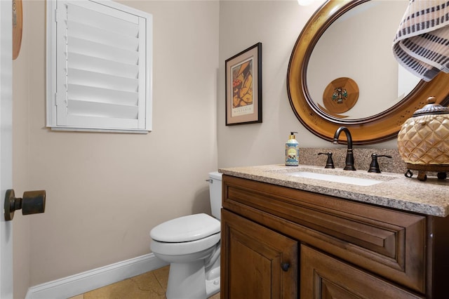 bathroom featuring toilet, tile patterned flooring, baseboards, and vanity